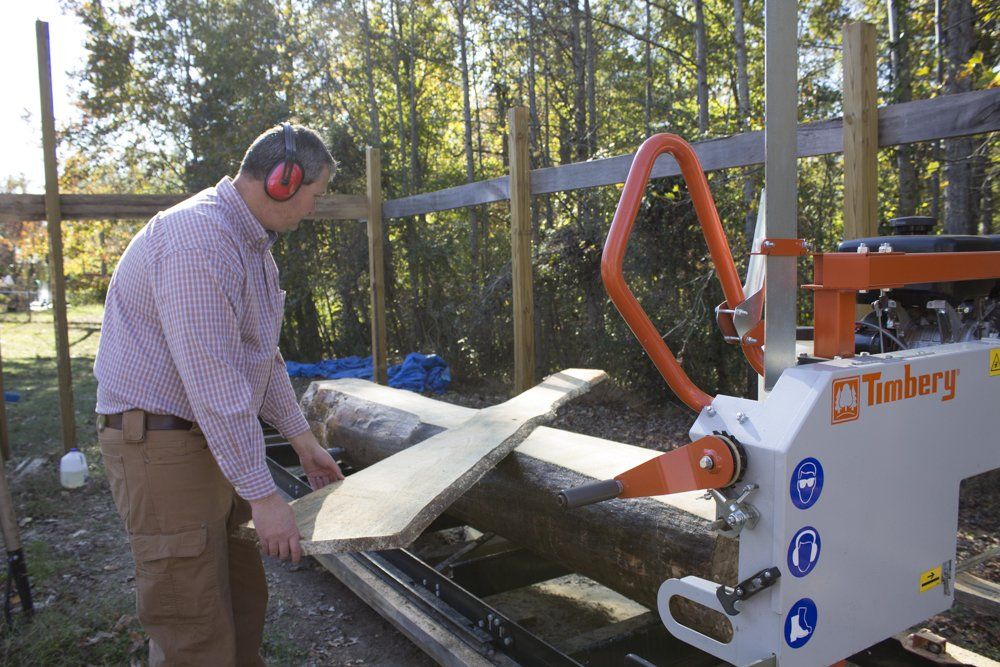 Hobby farmer sawing lumber on his Timbery M100 Sawmill