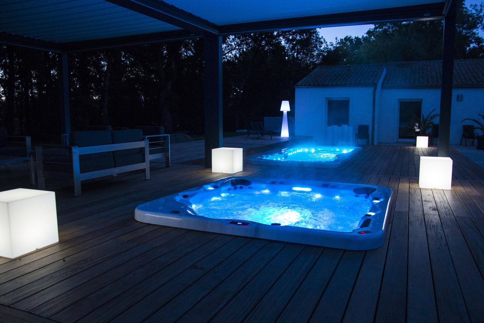 Un bain à remous est éclairé la nuit sur une terrasse