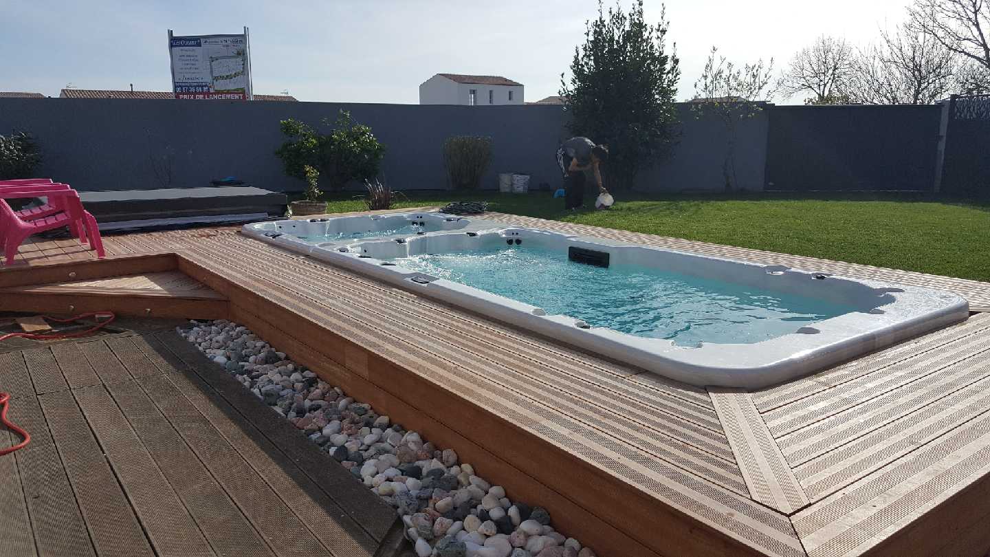 Une grande piscine posée sur une terrasse en bois