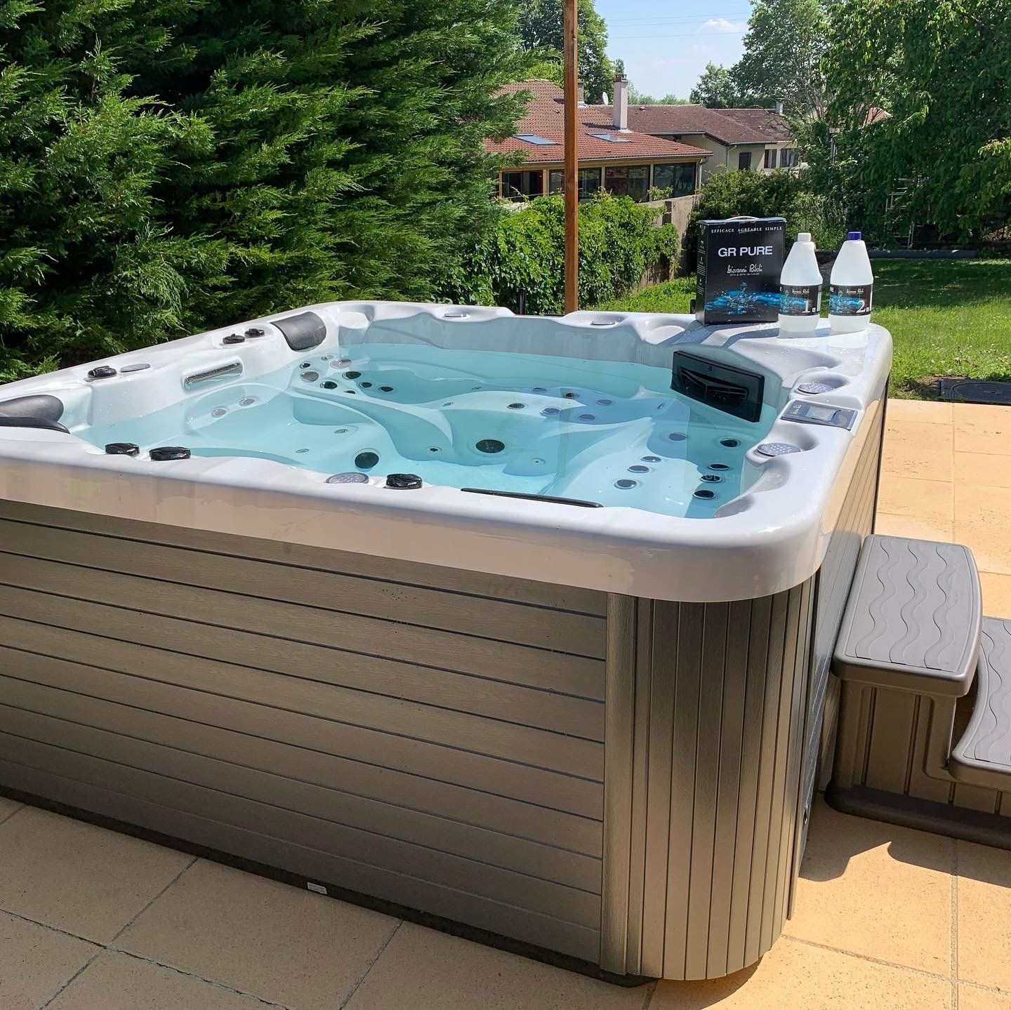 Un jacuzzi rempli d'eau bleue se trouve sur une terrasse
