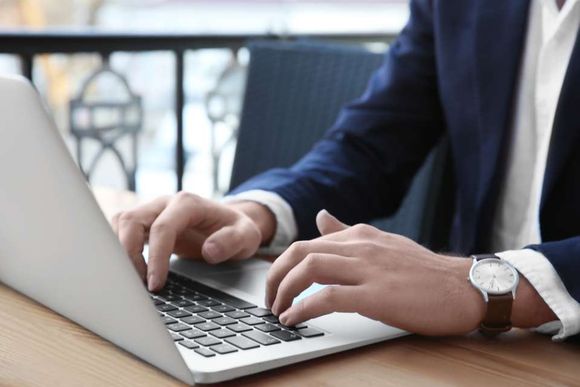 man typing on his laptop