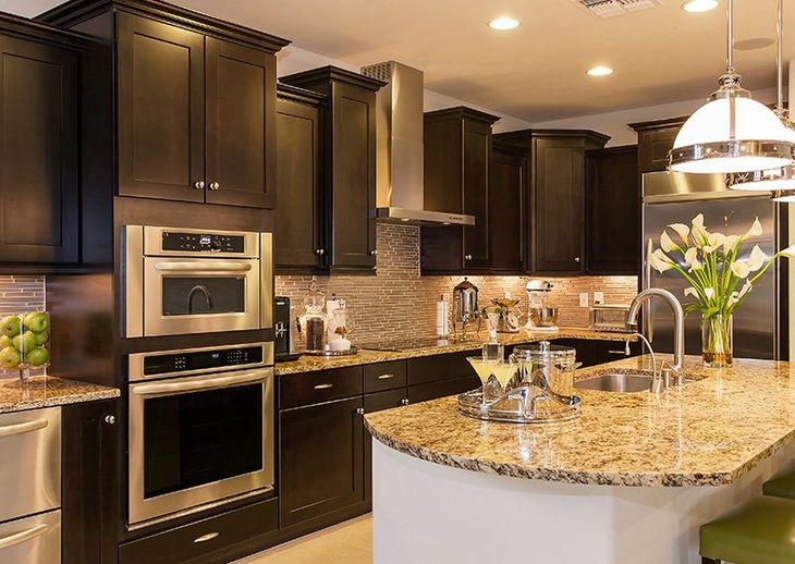 A kitchen with black cabinets and stainless steel appliances.