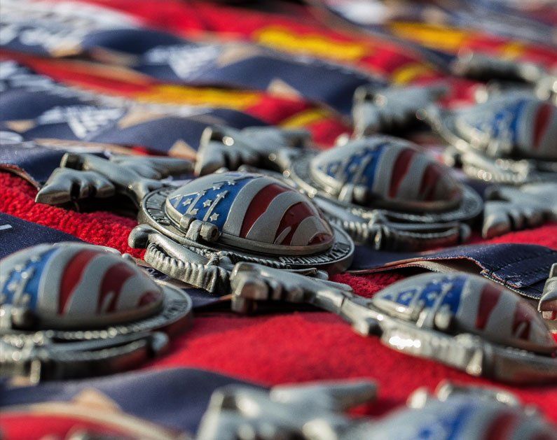 A bunch of medals are laying on top of each other on a table.