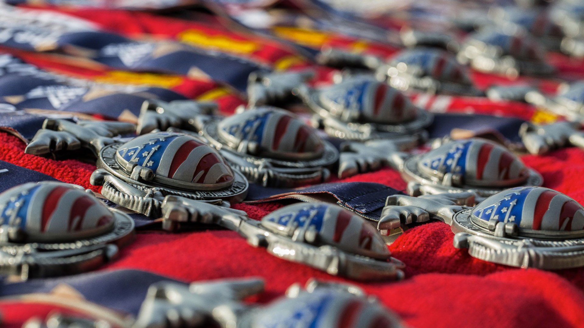 A bunch of medals are sitting on top of an american flag.