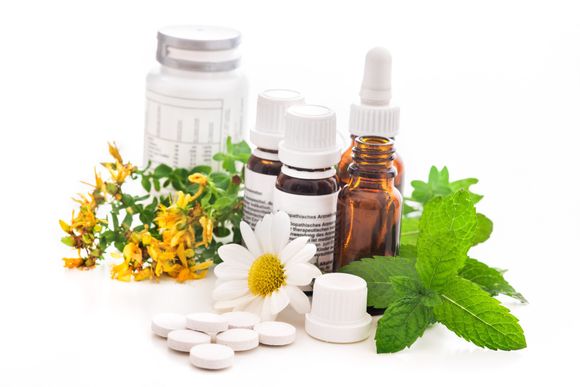 a group of medicine bottles , pills , flowers and mint leaves