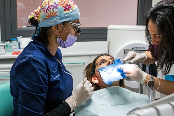 dentista che opera paziente