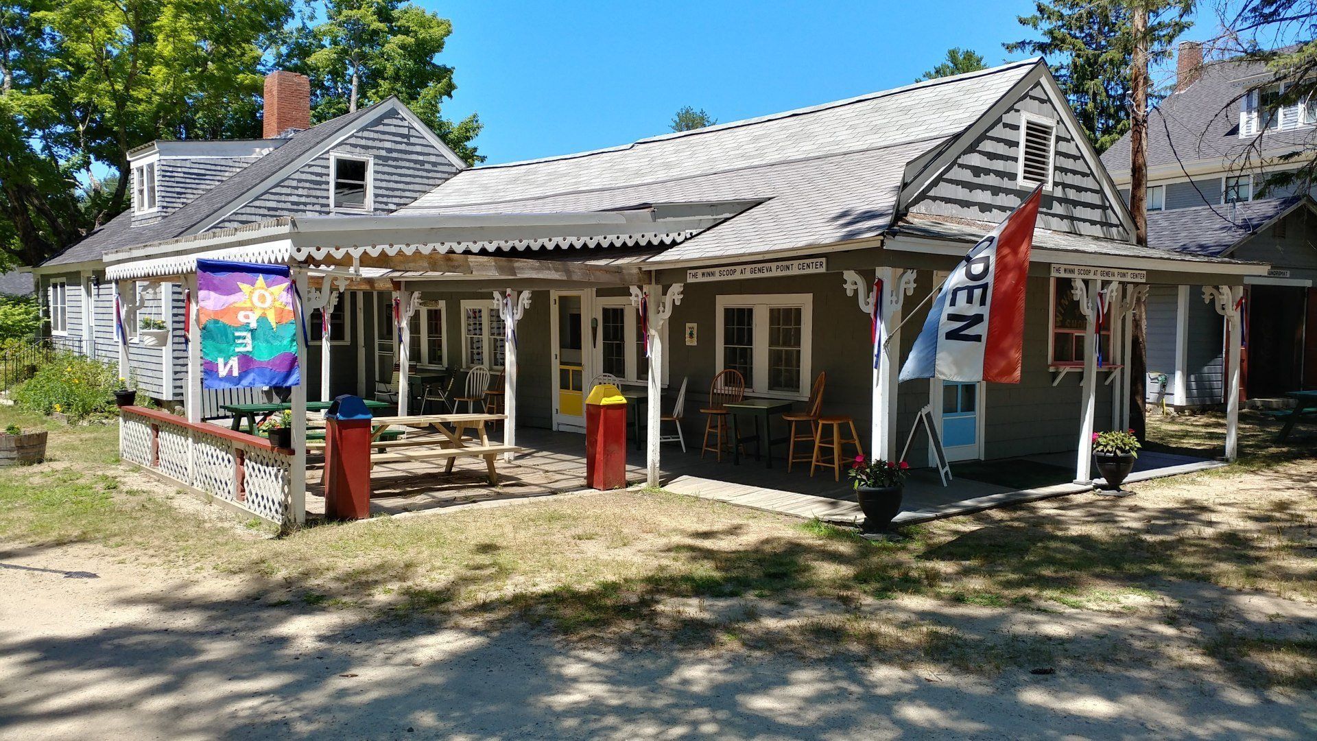 A large house with a porch and a sign that says open on it.