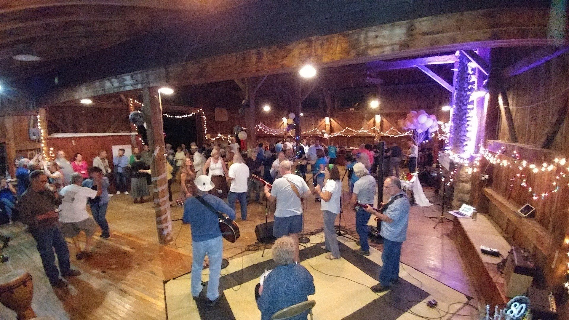 A large group of people are dancing in a large room.