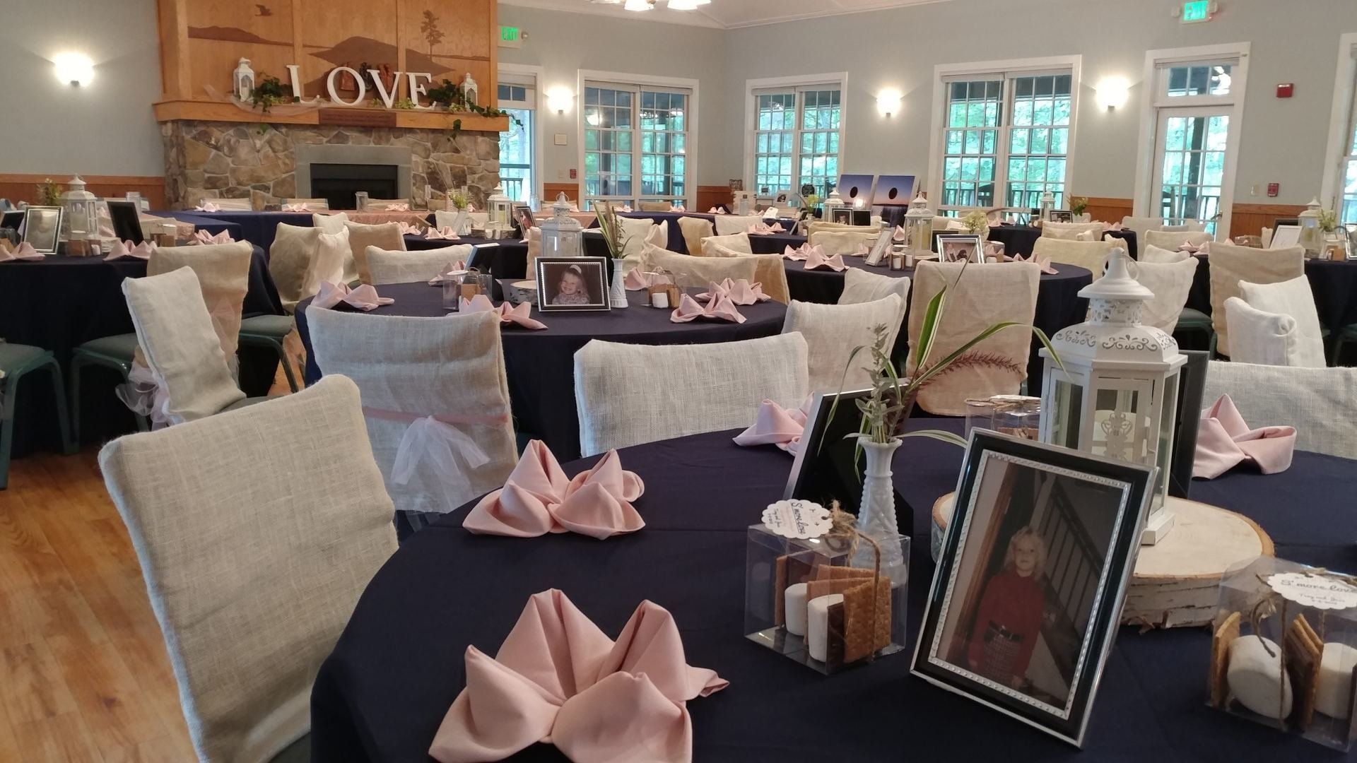 A large room with tables and chairs set up for a wedding reception.