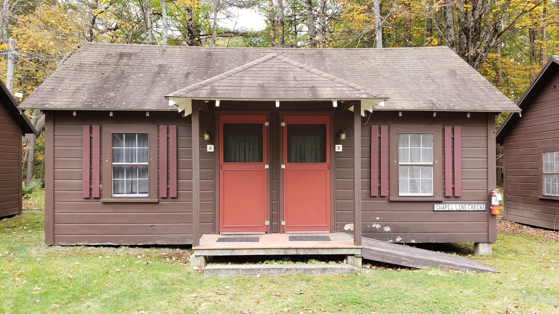 A small brown cabin with red doors and shutters
