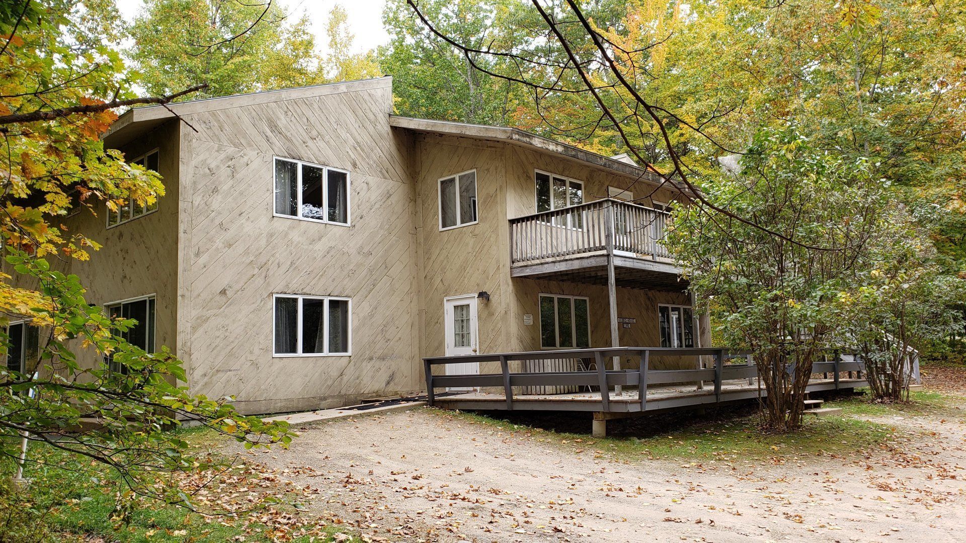A house with a deck in the middle of the woods