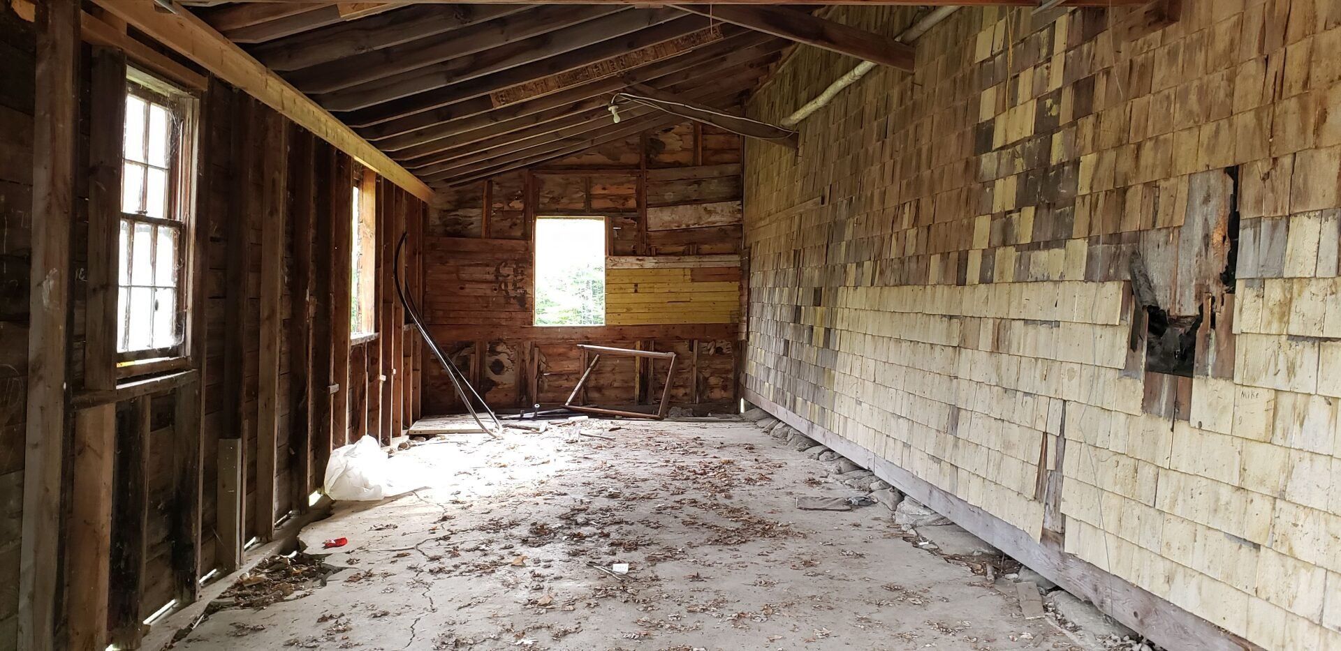 An empty room with a brick wall and a window.