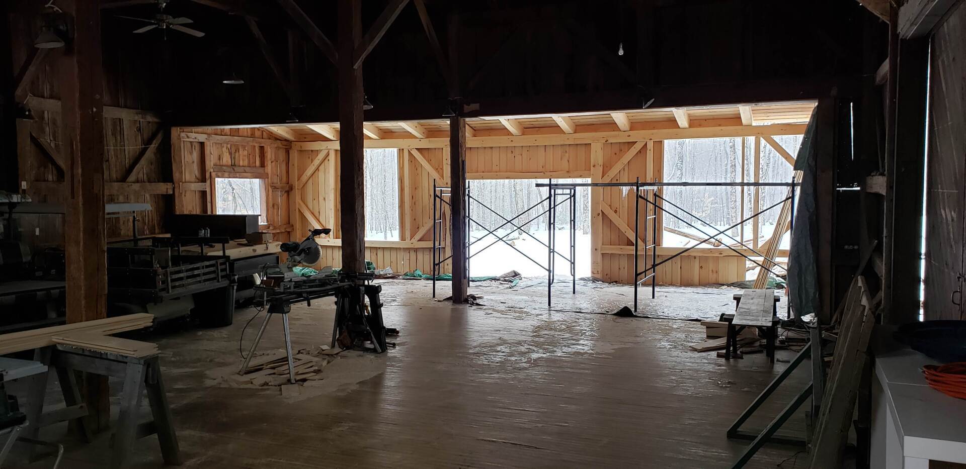The inside of a barn under construction with a lot of windows.