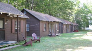 A row of cabins with red chairs in front of them