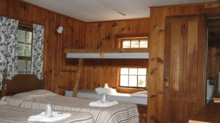 A bedroom with two beds and a bunk bed