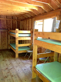 A room with bunk beds and chairs in it
