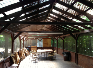 A large room with a table and chairs under a roof