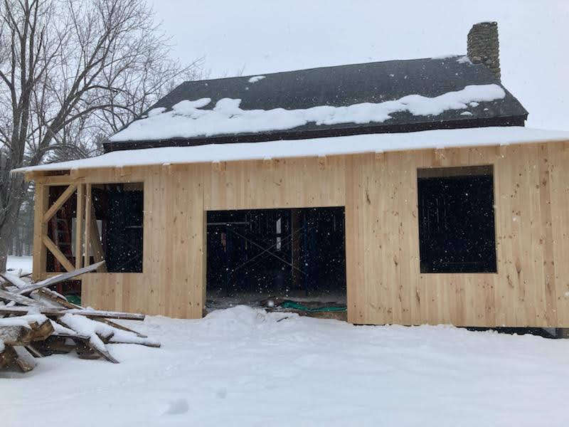 A wooden house is being built in the snow