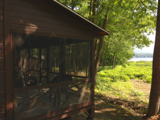 A screened in porch with a view of a lake