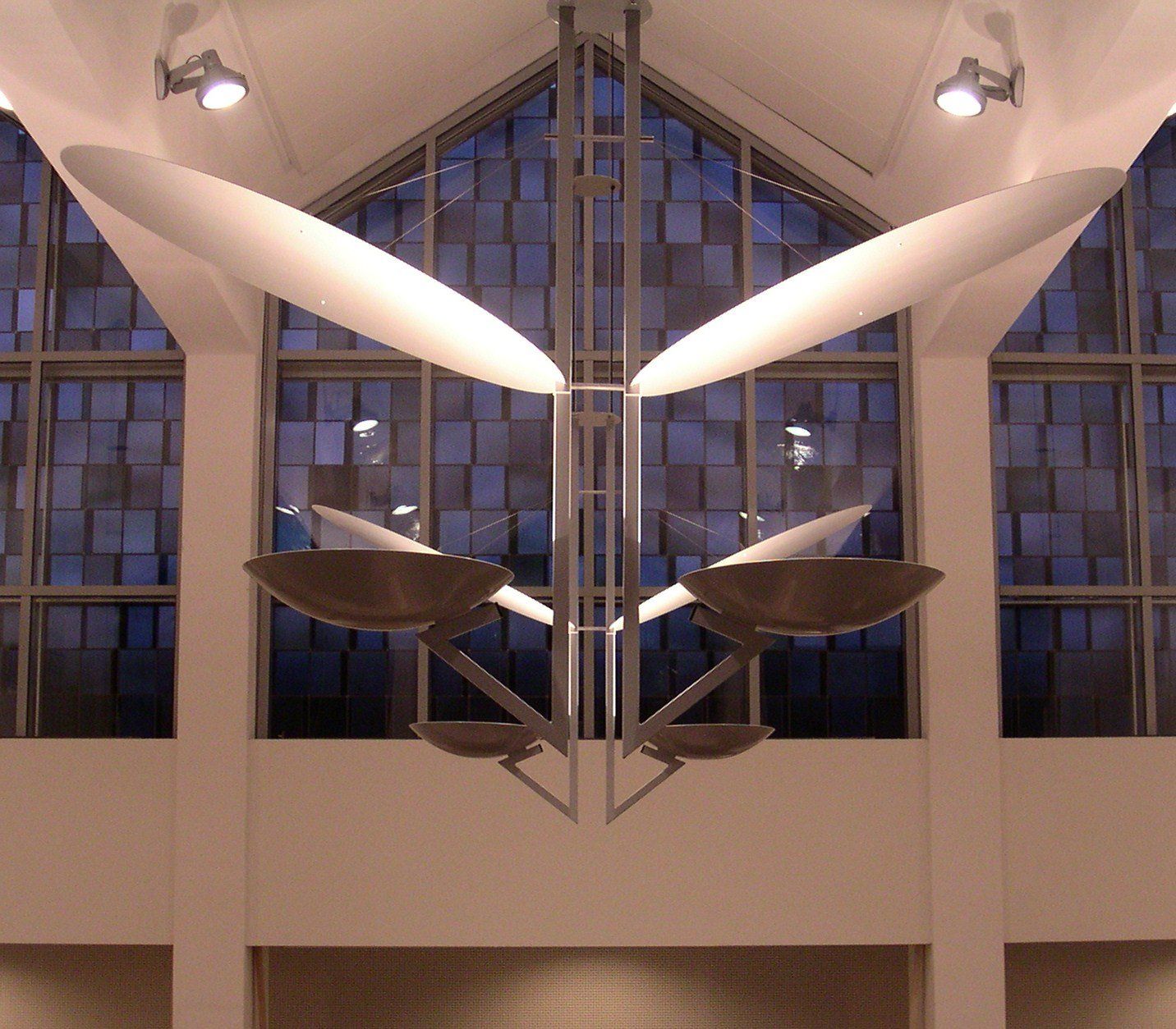 Symmetrisches, modernes Interieur mit Hängelampen und einer großen Fensterfront bei Nacht