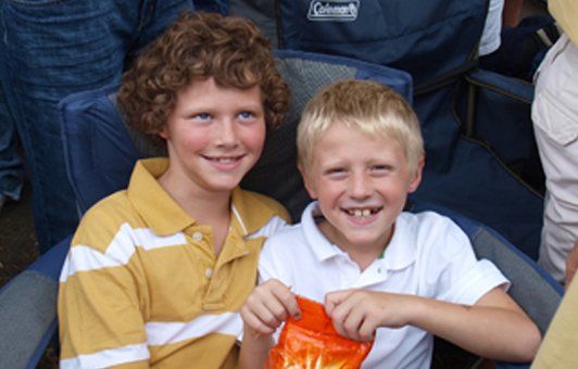 One has curly hair and a yellow shirt, the other has blonde hair and a white shirt.