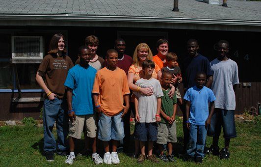 Group of people posing outdoors in front of a building.