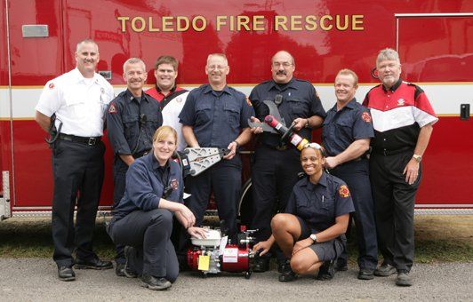 Toledo Fire Rescue team posing with rescue equipment in front of a fire truck.