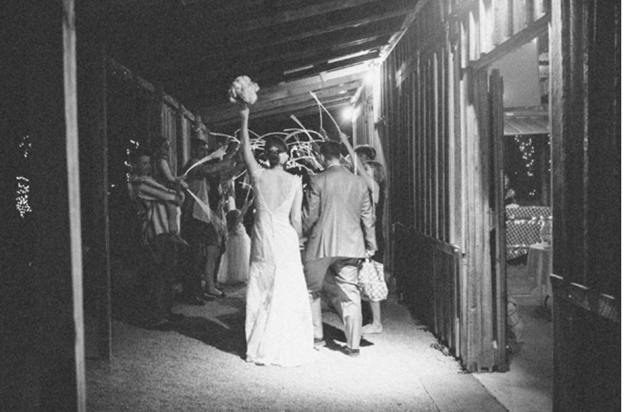 a black and white photo of a bride and groom walking down a hallway .