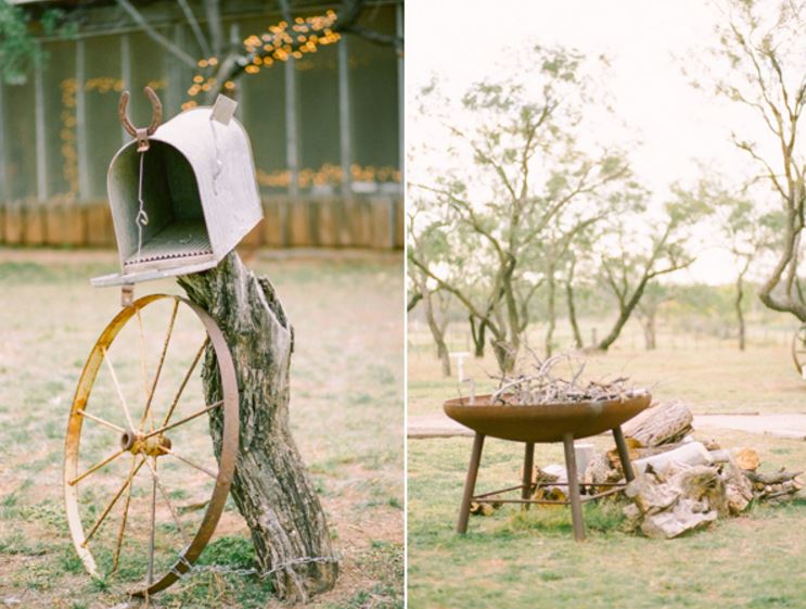 a mailbox is sitting on a tree stump next to a wagon wheel and a fire pit .