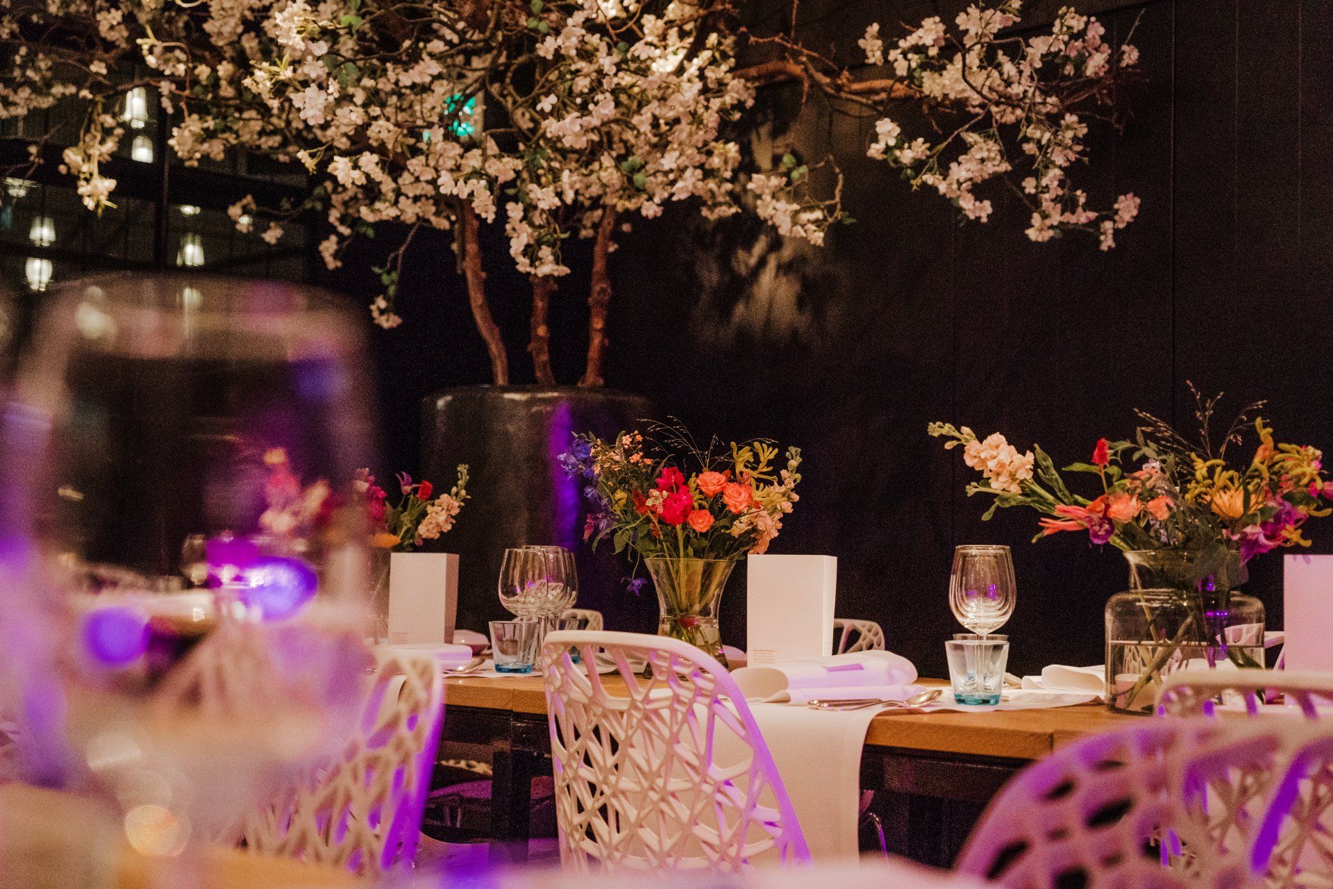 Een restaurant met veel bloemen op de tafels en stoelen