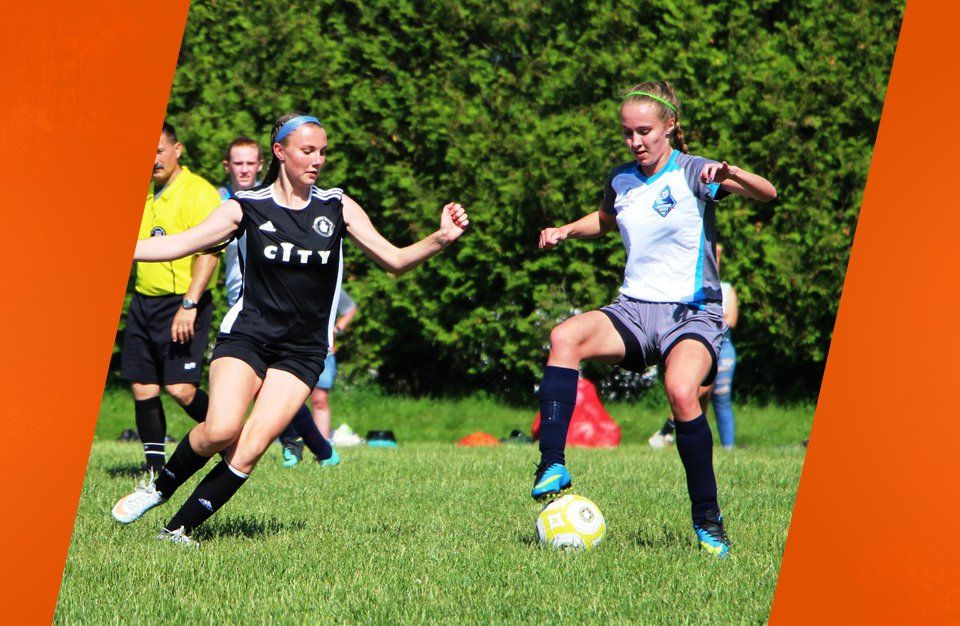 girl keeping soccer ball away from other team