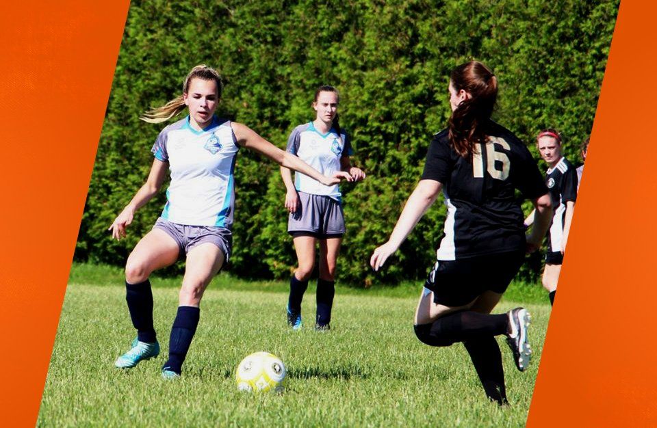 girl about to kick soccer ball