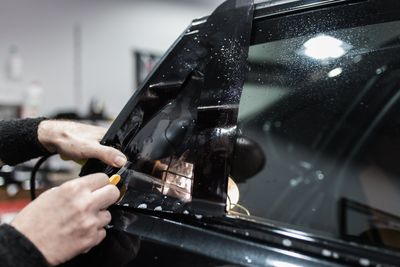 Window Tinting — Worker Applying Tinting Foil on Car Window in Belmont, CA