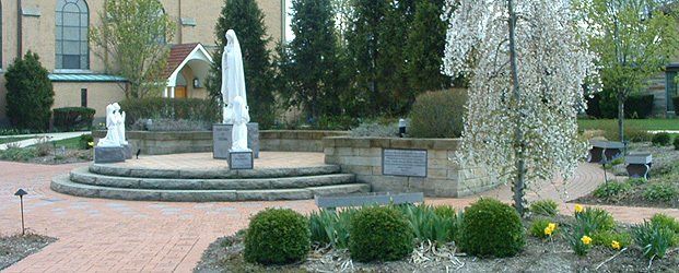 Brick pathway with steps to platform with statue