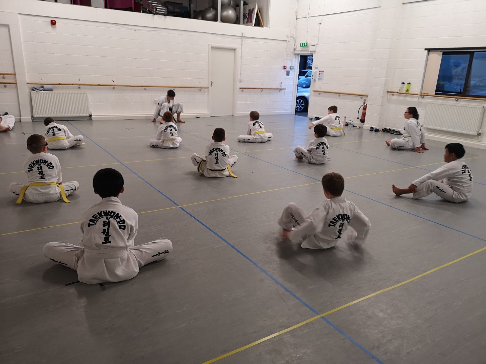 Tae Kwon Do students sat cross legged