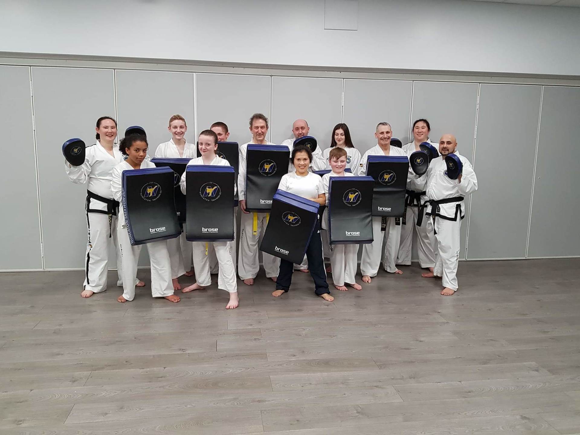 Group of adults holding up kickshields