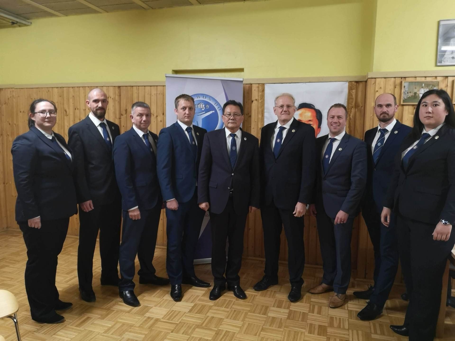 With Grandmaster Hwang Ho Yong other BTF International Instructors in Vienna Group lined up in navy suits in ITF Headquarters