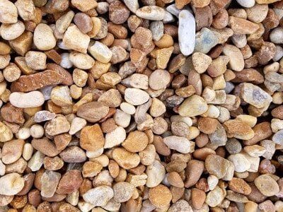 Close-up of small tan, brown, and white pebbles filling the frame