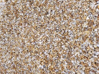Close-up of small beige, white, and tan pebbles or gravel filling the frame