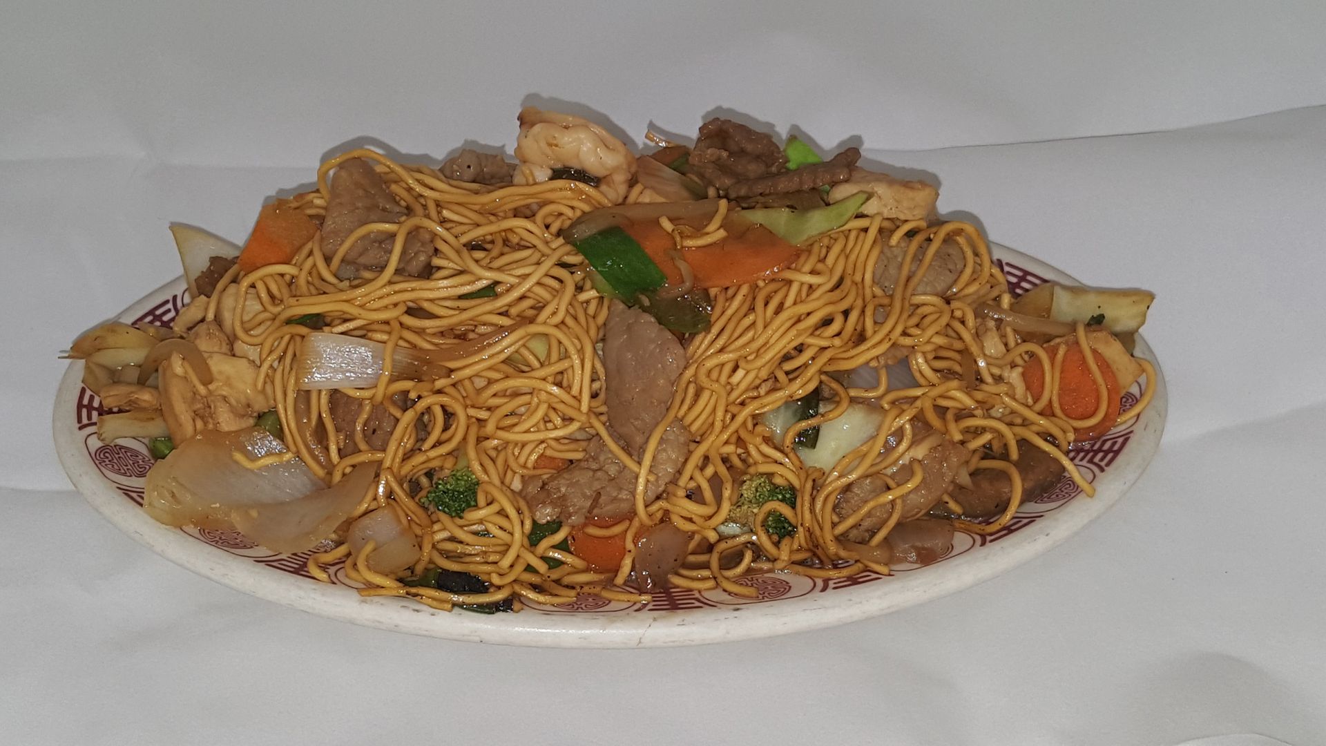Plate of noodles with vegetables and meat.