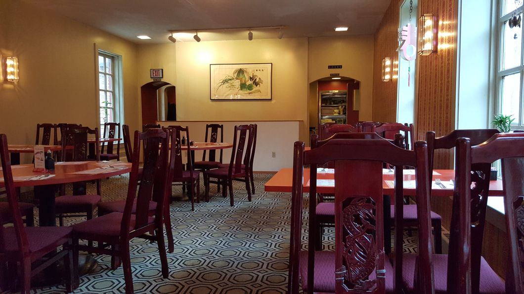 A restaurant with tables and chairs and a picture on the wall