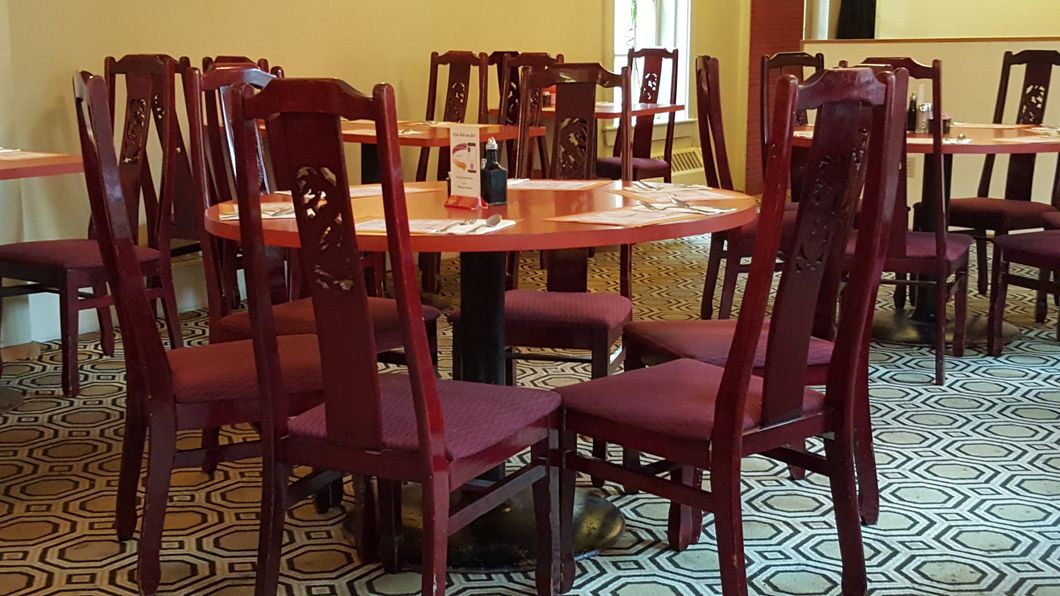 A restaurant with tables and chairs and a patterned floor