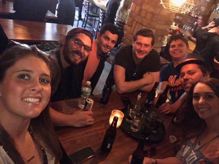 A group of people are sitting around a table in a restaurant