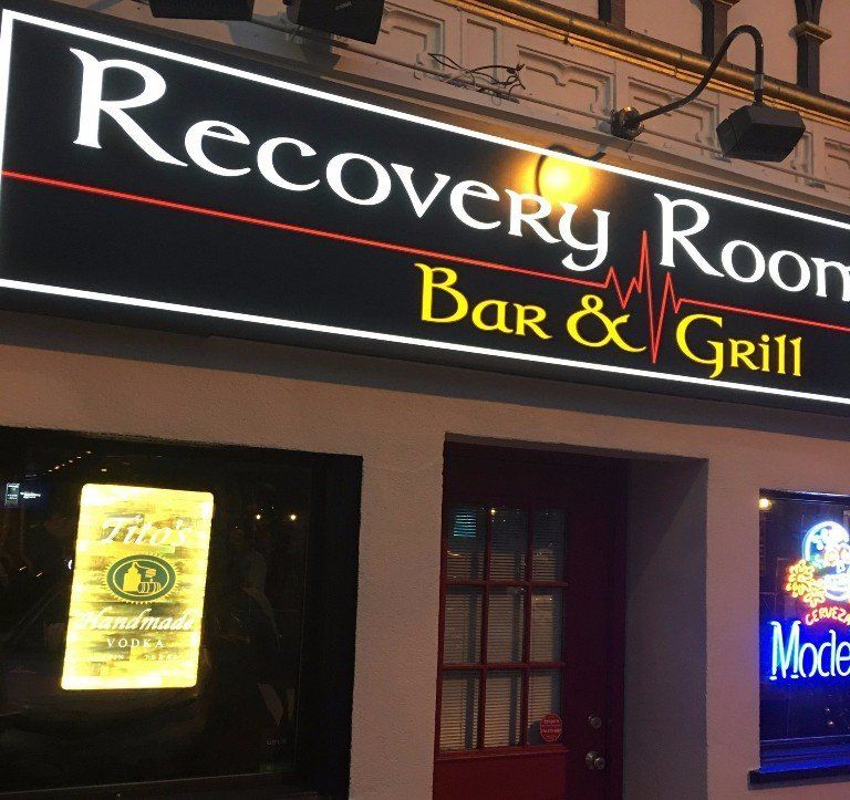 The recovery room bar and grill is lit up at night
