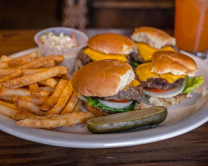 A plate of hamburgers and french fries on a table.