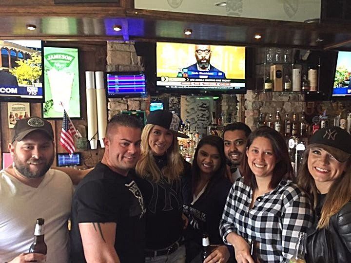A group of people are posing for a picture in a bar.
