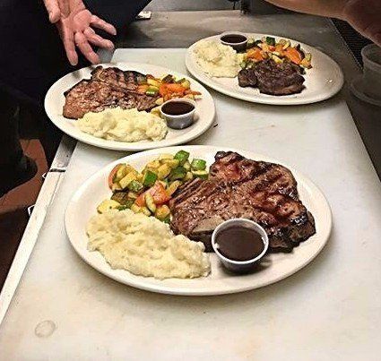Three plates of food are sitting on a cutting board on a table.
