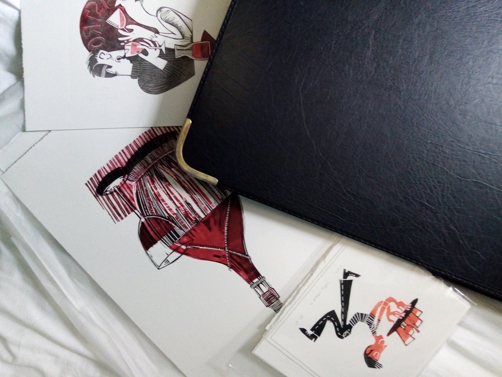 A selection of prints scattered round a portfolio case
