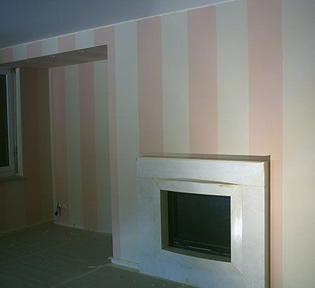 dei muri dipinti di bianco e rosa e un alloggio camino