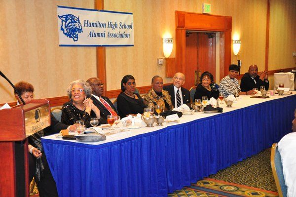 People seated at a table with a banner that reads 